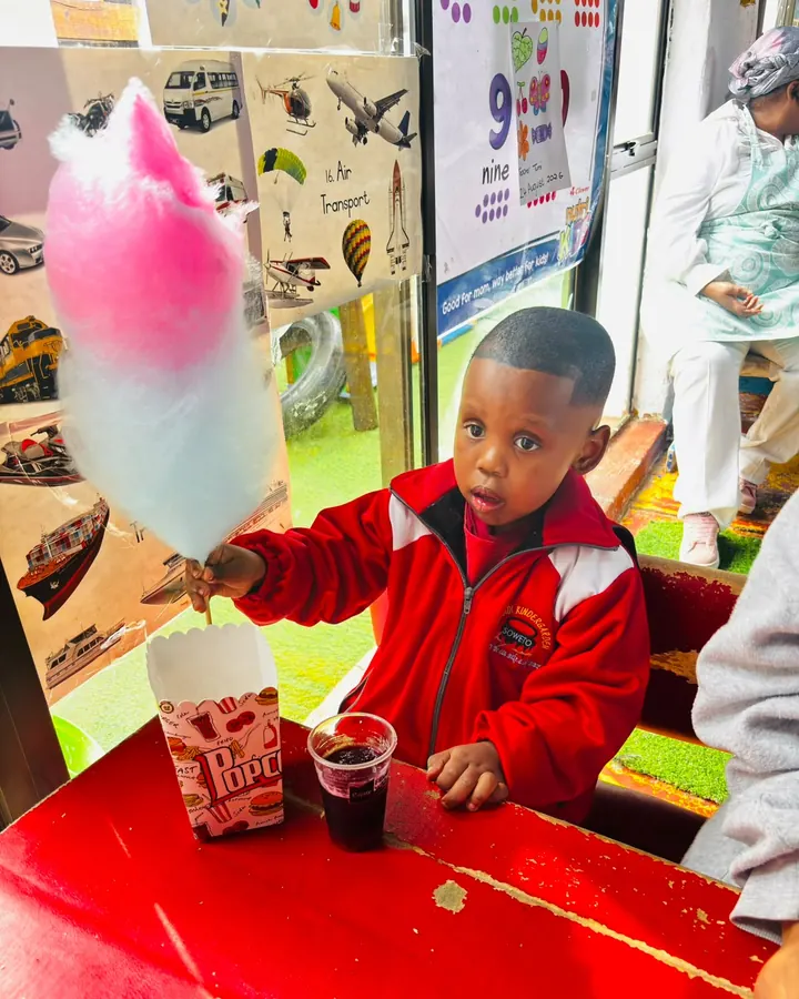 A child holding a large pink and blue candy floss