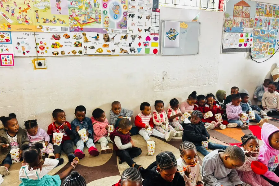A full class of children sitting with popcorn boxes and ice cream