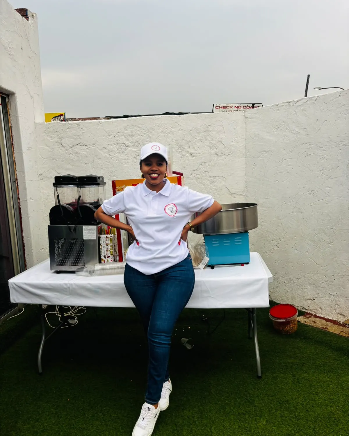 Gloria in Sedi Events uniform in front of the slush, popcorn and candy floss machines